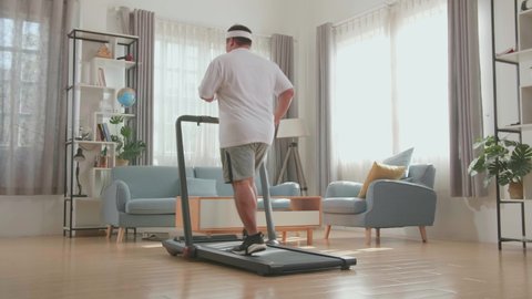 Back View Of Asian Fat Man Running On A Treadmill At Home At Home
