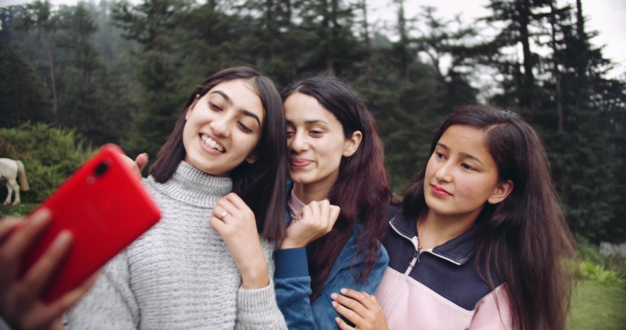Three South Asian girls taking a selfie in nature