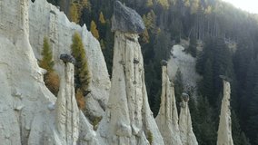 Aerial view on natural Earth Pyramids of Platten in autumn Dolomite Alps. Perca, Dolomites, Italy. UHD 4k drone video