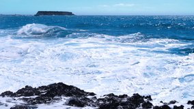 Sea storm 4k concept, landscape footage of ocean blue water and rocks, Sunny daytime seascape, Devastating and spectacular, ocean waves crash on the rocks of the coast creating an explosion of water