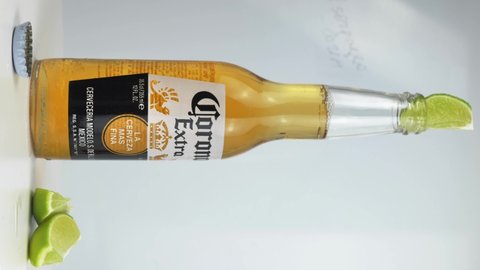 Rome Italy, July 16. 2021. A bottle of Corona Extra beer with lime on a white background, which, along with most of the beer sold worldwide, is pale-lager, produced by Cerveceria Modelo in Mexico