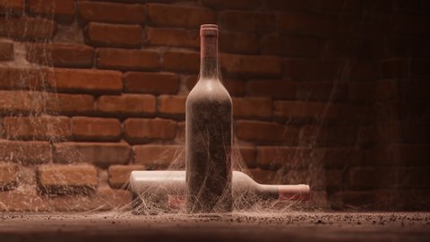 Old wine bottle covered in web inside abandoned cellar on bricked background. Aged alcoholic wine. Second bottle in the backdrop. Camera rotating around the subject.
