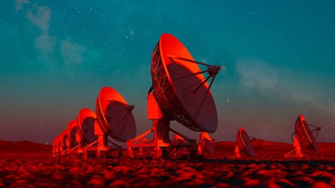 Set of satellite dishes in the desert at vibrant sunset. Space observatory signal search. Radio astronomy observatory. Colourful landscape with antennas silhouettes. Discovery, science, technology.