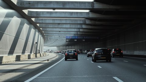 The Hague, The Netherlands - Circa 2019: Driver pov at the front driving cars Renault, VW, Volvo on dutch highway covered tunnel with speed limit signage of 50 km per hour