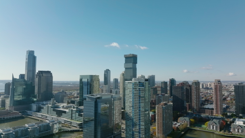 Slide and pan footage of modern high rise downtown buildings on Hudson river waterfront. Jersey City, USA
