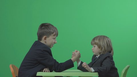 Brothers arm wrestling on green screen