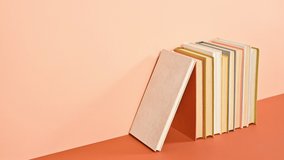 6k Stack of vintage books appear ordered on deep and bright orange theme. Stop motion - Powered by Shutterstock - Get 15% off with code: PIKWIZARD15