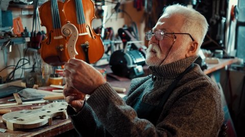 Elderly male master works in his workshop