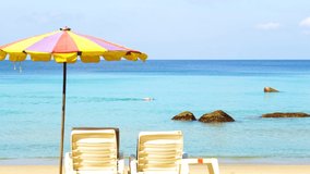 Umbrellas and chairs colourful on sandy beach. Tourists travel relax summer vacation holiday. Landscape best beaches Phuket,Thailand. Phuket sand box. Video 4k footage 2022.