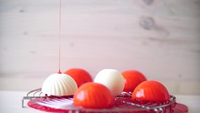 Pastry chef pours white individual mousse cakes with red mirror glaze - Powered by Shutterstock - Get 15% off with code: PIKWIZARD15
