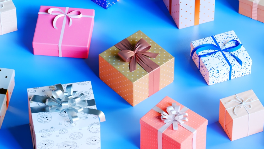 Decorative boxes with ribbons. Concept of Christmas celebration, anniversary, wedding, birthday, valentines day. Blue background. Endless camera motion. Family time. Santa Claus. Colorful decorations