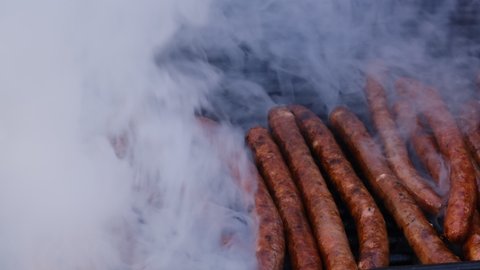 sausage grilling over a barbecue fire on a hot day during the summer vacation