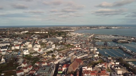 Drone footage over St Peter Port Guernsey panning north to east including harbour castle and islands