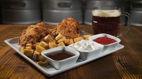 Fried chicken tenders and home fries with a trio of dipping sauces paired with a dark lager, slider 4K