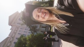 In the modern college garden very beautiful young lady student graduate make a selfie video for memory she speaks something very excited wearing graduation suits and caps - Powered by Shutterstock - Get 15% off with code: PIKWIZARD15