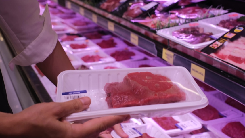 Human hands holding packaged fresh meat fillets, choosing beef for cooking in supermarket, butcher's shelves  | Shutterstock HD Video #1084063063