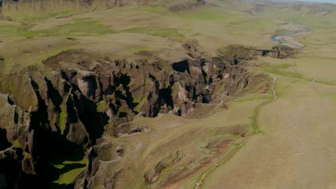 Top down view panorama of Fjadrargljufur canyon, a 100 meters deep gorge in south Iceland. Drone view of majestic rock formation caused by erosion of Fjadra river flowing through it