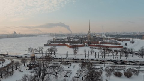 Drone footage of winter view of St. Petersburg at sunset, frozen Neva river, steam over city, Peter and Paul fortress, car traffic on Trinity bridge, rostral columns, Palace drawbridge, panoramic view