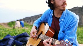 slow motion on young romantic man at park playing guitar and singing for his beautiful girlfriend - Powered by Shutterstock - Get 15% off with code: PIKWIZARD15