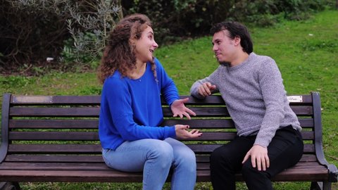 young woman in the park is excluded from the conversation by two mutual friends