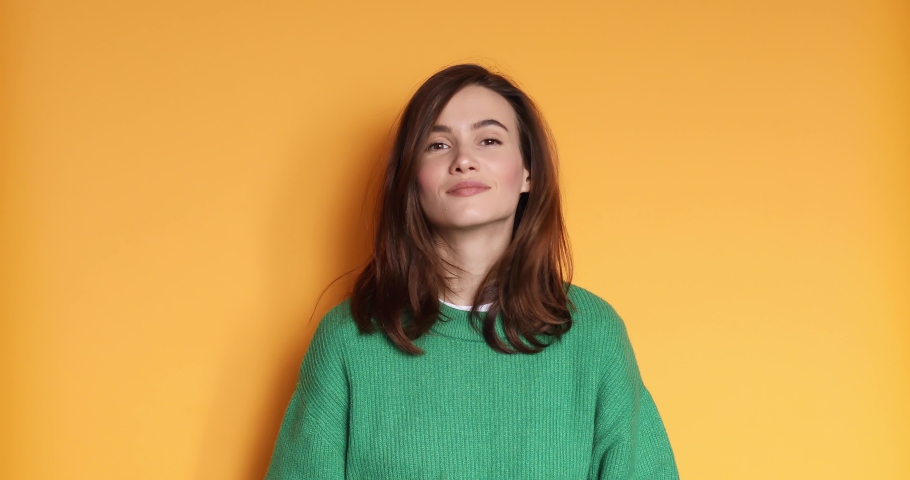 Young woman in green sweater making good-bad sign isolated on yellow background. Girl make choice, or makes a decision thumb up or tnumb down, like or dislike, yes or no.  | Shutterstock HD Video #1084084153