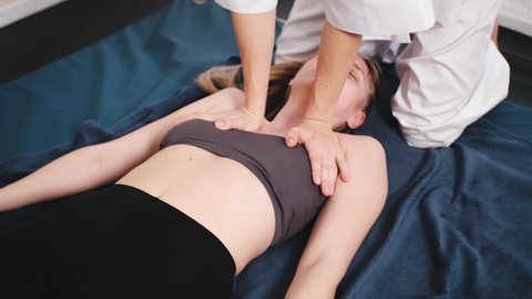 Masseur makes chinese massage of neck and decollete of woman in clinic