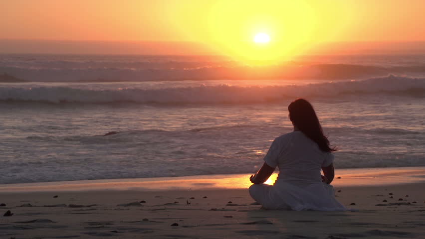 Woman meditating on the beach at sunset | Shutterstock HD Video #10840964