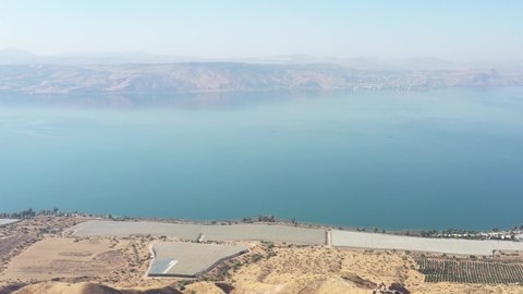 Santa Claus Riding a bicycle on the view of the Sea of ​​Galilee
Drone Aerial Shot Over Forward Santa Riding a bicycle in the middle of the day at the North, Israel.