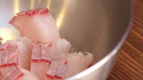 A video of yellowtail (Hamachi) sashimi soaked in sauce.
