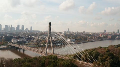 Amazing modern transport construction, tall cable stayed Swietokrzyski Bridge over Vistula river. Cityscape in background. Warsaw, Poland