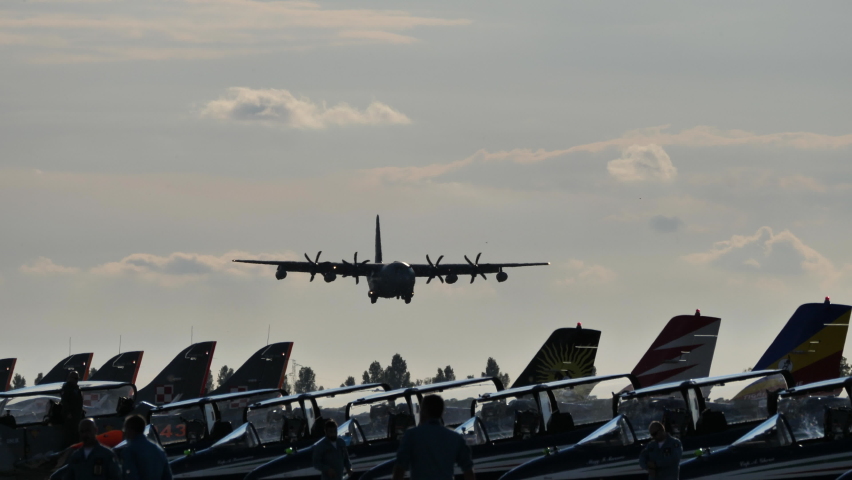 Rivolto , Italy SEPTEMBER, 17, 2021 Tracking view aircraft slowly land on runway with crew watching by many standing planes at Rivolto air show display. Lockheed Martin C-130J Super Hercules of