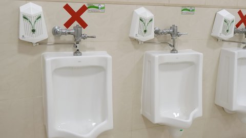 Men's restroom clean white porcelain urinals in line. Modern public toilets, WC. Social distance. Close up, dolly move, 4k, 10 bit, 422, 50 fps