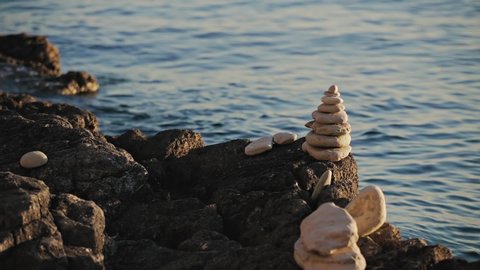 Zen stones on a ocean sea cliff in sunset sunrise time.	
