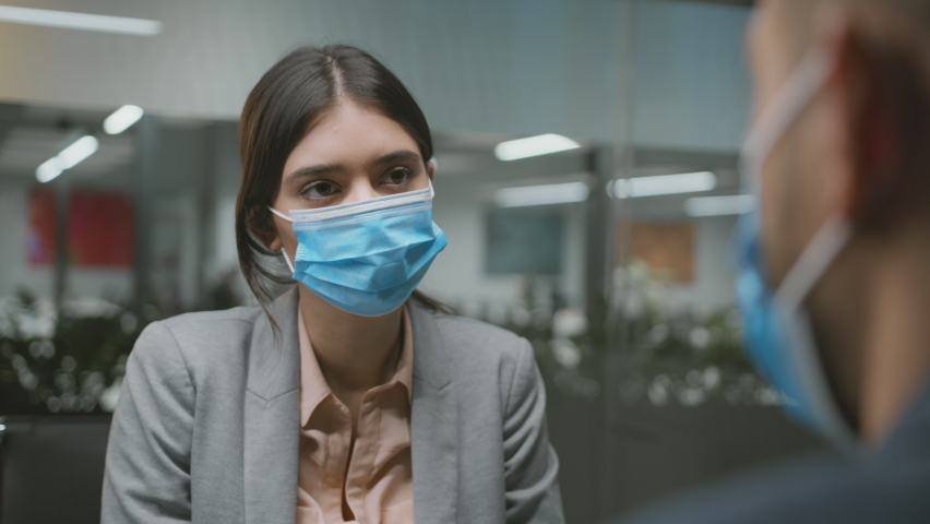 New normal and job employment. Young woman talking to male jobseeker, asking questions, both wearing protective medical masks, slow motion Royalty-Free Stock Footage #1084119184