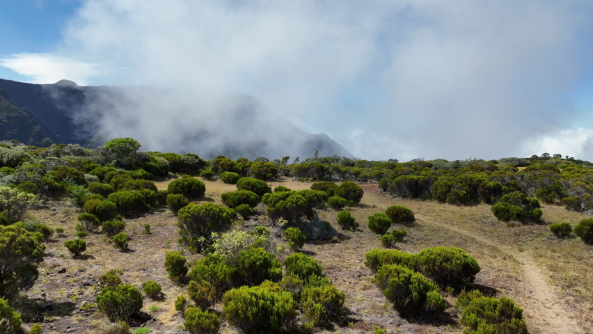 Aerial view of volcano and hills at Réunion Island with fog and clouds