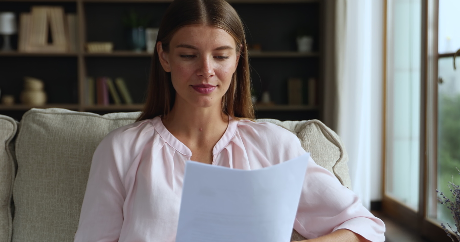 Sad young woman sit on couch read paper letter correspondence with bad news, bank debt, loan reject, feels stressed about unpaid tax penalty, eviction notice, student worried college expulsion concept Royalty-Free Stock Footage #1084126105
