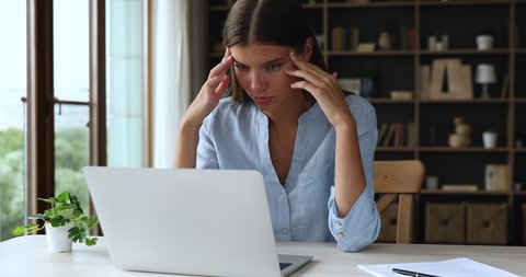 Discontented woman swears at broken or slow computer seated at desk look at device screen feels annoyed, need laptop repair, experiencing lack of understanding, new software, malware, failure concept
