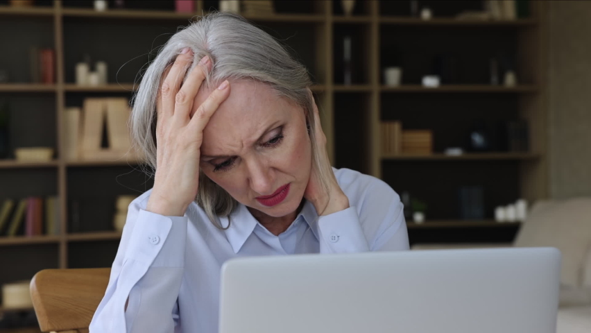 Nervous worried old age businesswoman look on laptop screen with indecision hesitate make difficult choice in risky situation. Anxious mature lady employee lost in thoughts ponder on business problem Royalty-Free Stock Footage #1084126501