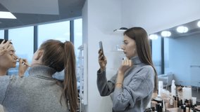 Video to your smartphone for a beauty blog. Makeup artist and blogger made a video tutorial on makeup. Beginner make-up artist records a professional make-up artist's lesson on the phone