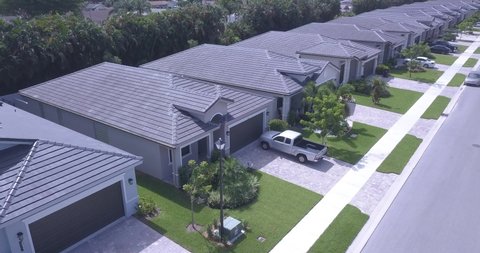 Aerial drone footage of brand new South Florida residential neighborhood, showing street, houses, cars, and landscaping. The cinematic footage showcases the essence of South Florida Real Estate.