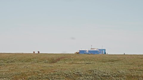 Faraway view of researchers camp who walk doing routine. Yamal peninsula in the afternoon.