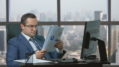 Man with suit at office analyze papers with counting and statistics, city view