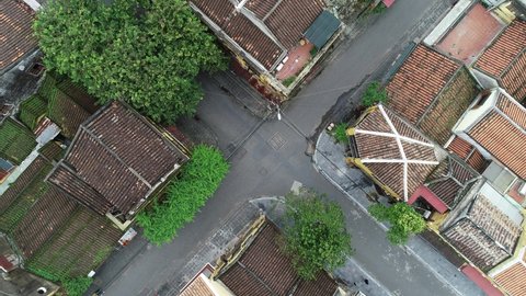 Hoi An Ancient Town, Viet Nam 2021 - Old town on both sides of Hoai River viewed from above - Flycam topshot - flying over the rooftops 