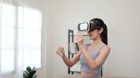 Training with virtual sport at home. Young asian sport woman wearing sportswear workout exercise stretching put on vr glasses into virtual simulated world.  Future digital cyber universe.