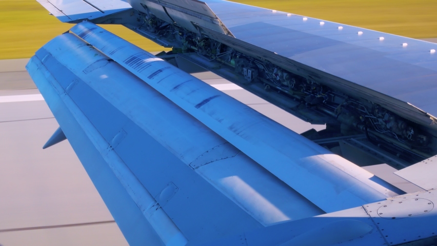Close-up of a wing of a passenger plane with open mechanisms for braking during landing. View of the airplane wing with internal hydraulics. Flight on a plane through the eyes of a passenger. Royalty-Free Stock Footage #1084148368