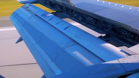 Close-up of a wing of a passenger plane with open mechanisms for braking during landing. View of the airplane wing with internal hydraulics. Flight on a plane through the eyes of a passenger.
