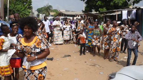 Abidjan, ivory coast - December 12, 2021: group of young people dancing to the sound of the fanfare during a traditional wedding ceremony in Abidjan.