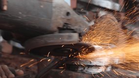 Man works circular saw. Sparks flying from hot metal. Man hard worked over the steel. slow motion shot in garage 4k clip
