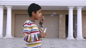An attractive child blowing bubbles - Bubbles from soap solution, childhood, picnic, fun time. Young boy doing a leisure activity outdoors - happy childhood - Powered by Shutterstock - Get 15% off with code: PIKWIZARD15