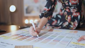 Close up hand choosing color from color sample swatch,asian female designer interior working at home studio hand picking sample of material color tone for her new house design project - Powered by Shutterstock - Get 15% off with code: PIKWIZARD15
